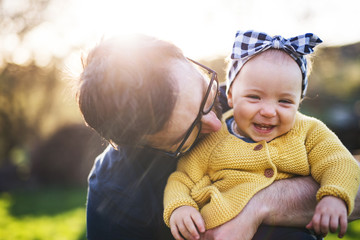 Wall Mural - A father with his toddler daughter outside in spring nature.