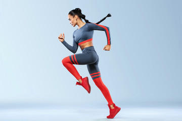 Wall Mural - A strong athletic, women sprinter, running wearing in the sportswear, fitness and sport motivation. Runner concept with copy space. Dynamic movement