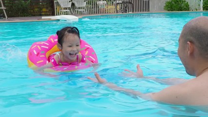 Wall Mural - Little asian girl swimming with her father at swimming pool