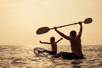 Poster - Father and son  playing on the beach at the day time.