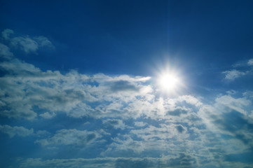 rays of sun with clouds against the blue sky