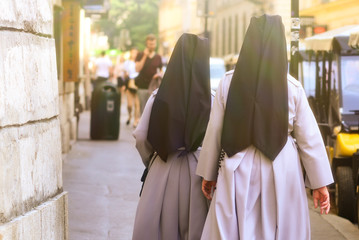 The nuns are walking along the city street