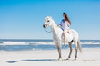 © Photocreo Bednarek - Girl sitting on a white horse by the sea