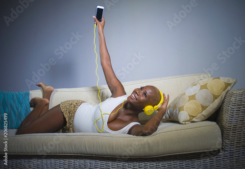 Poster young happy and beautiful relaxed black afro American woman listening to music w