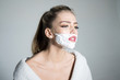 © Volodymyr - Side view woman with shaving foam on her face isolated on gray background. Girl with high ponytail wearing white bathrobe, transgender concept