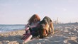 Happy young woman playing with her German shepherd dog outdoor on the beach, slow motion