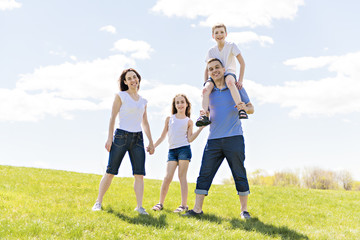 Wall Mural - Family of four outdoors in a field having fun