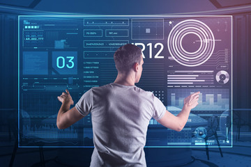 calm specialist. attentive experienced programmer touching a transparent screen and looking calm whi