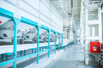 Interior of clean production workshop at food factory, modern machine units lining long hall, copy space