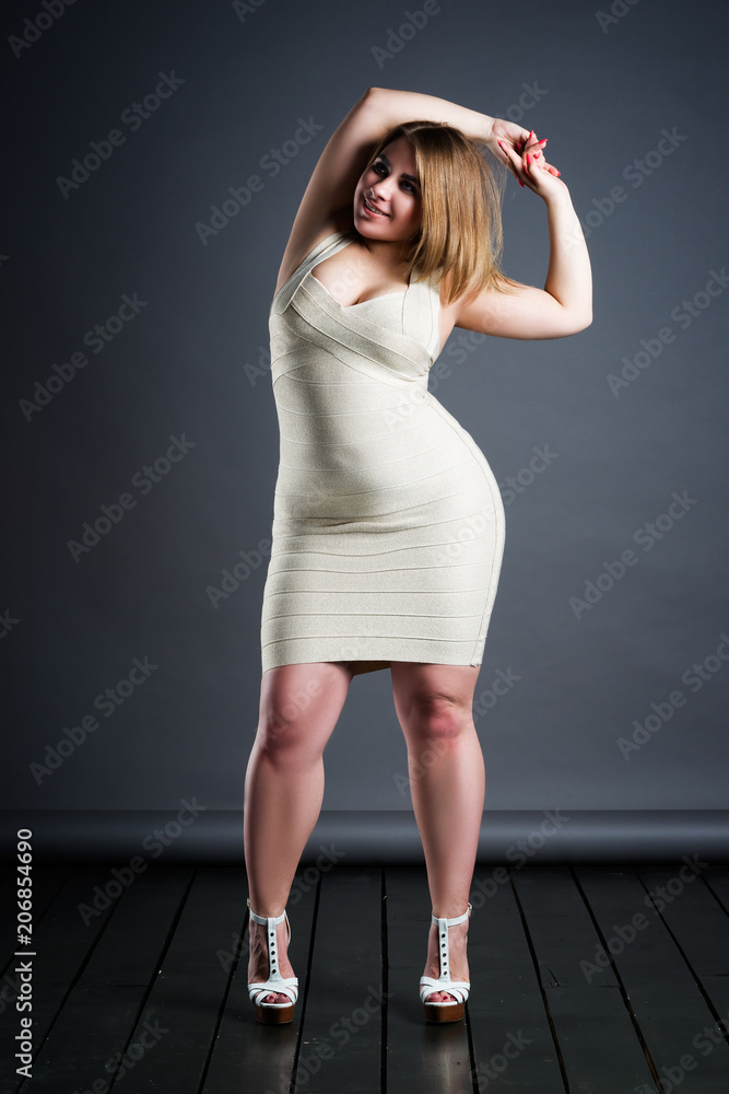Plus size fashion model in dress, fat woman on gray studio background, overweight  female body Stock Photo | Adobe Stock