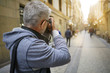 © goodluz - Photographer in European city taking picture of buildings