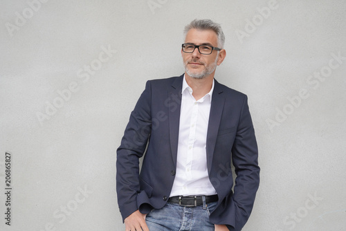 Fotografía Businessman leaning on concrete wall, isolated