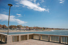 Overview In The Foreground Of Marble Pier, With The Beach And The City Of Ostia In The Background, On A Sunny Day. The Town Is A Seaside Resort And Ancient Port Of Rome. Located In The Lazio Region