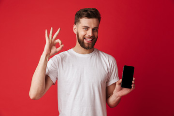 Young man showing display of mobile phone make okay gesture.