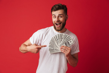 Poster - Excited young man holding money pointing.