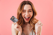 Cheerful Brunette Woman In Dress Holding Credit Card And Rejoices