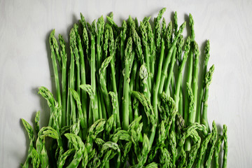 fresh green asparagus decorated on white wood kitchen plate, can be used as background