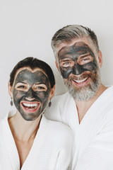 Happy couple wearing a charcoal mask