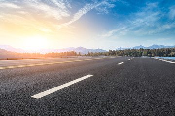 Asphalt road and hills with sky clouds landscape at sunset