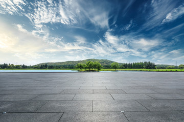 Empty square floor and hills with sky clouds