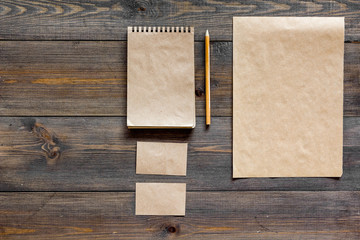 Mockup business brand template. Blank stationery and accessories made of craft paper for branding on dark wooden background top view mockup pattern copy space