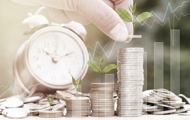 Close up of male hand stacking gold coins with green bokeh background ,Business Finance and Money concept,Save money for prepare in the future.