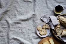 Gluten-Free Baguette, Cheese And Oil On A Gray Linen Background
