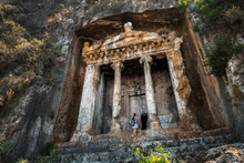 Amyntas Rock Tombs - 4th BC Tombs Carved In Steep Cliff. Tourist Stands In Front Of The Door. City Of Fethiye, Turkey.