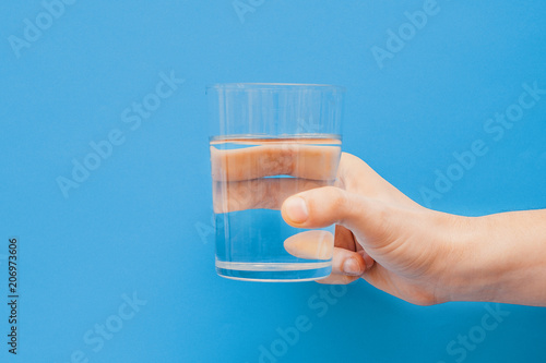 Fotomural Drinking water concept one hand holding glass
