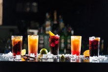 Multi-colored Alcoholic Cocktails With Citrus In Glasses Of Different Shapes On The Bar.