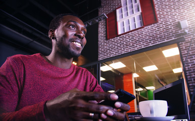 African american business man with laptop in a cafe.