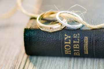 soft wedding ring bands with diamonds displayed on a black leather holy bible