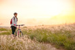 © Maksym Protsenko - Young Woman Riding Mountain Bikes in the Beautiful Field of Feather Grass at Sunset. Adventure and Travel.
