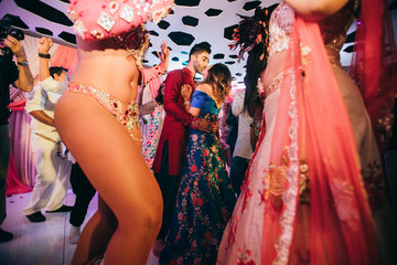 Beautiful Hindu newlyweds in traditional clothes dance on the party