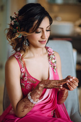 Wall Mural - Portrait of beautiful Hindu bride in pink sari getting ready for the ceremony in hotel room