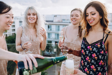 Canvas Print - Woman with henna tattoos holds a glass with champagne