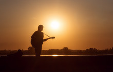 Silhouette Of A Guitarist At Sunset