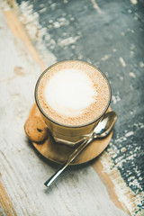 Wall Mural - Latte coffee in glass over wooden textured background.