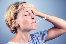 Sick Woman With Seasonal Flu Measuring Body Temperature With Thermometer In Her Mouth Reaching 38 Degrees Celsius