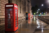 Fototapeta Londyn - Popular tourist Red phone booth in night lights illumination in London, England, United Kingdom
