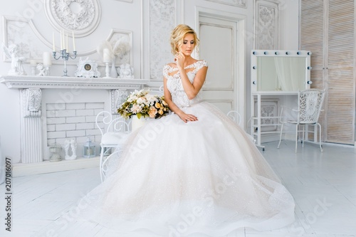 Fotografía A bride with hairstyle and make up in gougeous wedding dress preparing for the wedding