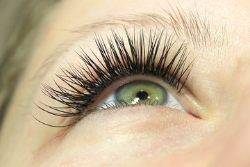 Beautiful Woman with long lashes in a beauty salon. Eyelash extension.