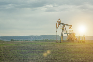 Wall Mural - oil pump, production. against the background of the sky of the mountains.