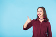 © satura_ - Cheerful young brunette caucasian student girl showing thumbs up on blue background with copy space