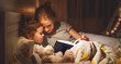 © JenkoAtaman - mother and child reading book in bed before going to sleep .