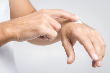 Man applying hand cream on white background, closeup