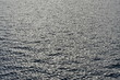 Sea surface covered with tiny choppy waves reflecting silver light.