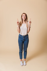 Poster - Full length portrait of a happy girl pointing finger up