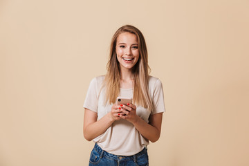 Wall Mural - Portrait of a pretty casual girl holding mobile phone
