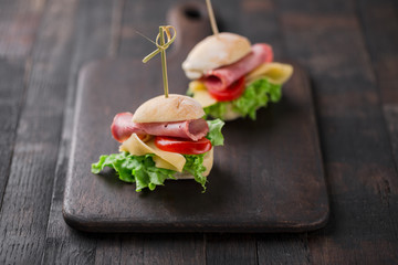 Wall Mural - mini sandwiches with lettuce, tomato, yellow cheese and ham, party snacks